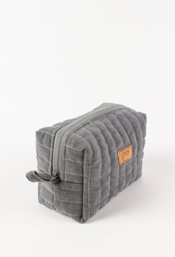 Bok szarej lnianej kosmetyczki box z metalowym zamkiem, detal szycia i struktury materiału