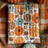 Jesienne pikowane etui na książkę z bawełny w dyniowy wzór. Miękkie book sleeve chroni książkę przed zarysowaniami i zagięciami podczas noszenia w torebce lub plecaku. Idealne dla miłośników jesieni, cozy reading i ręcznie szytych akcesoriów.