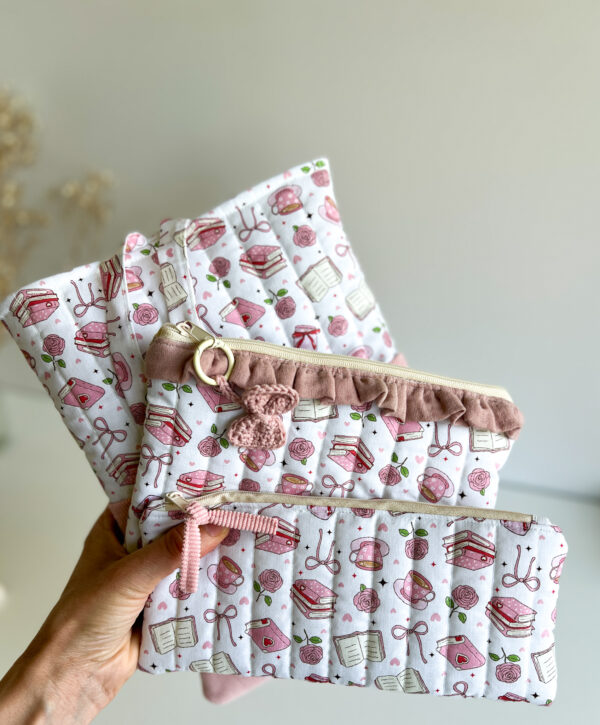 Komplet handmade w różowej kolorystyce z ilustracjami książek, herbaty i kwiatów, zawierający torbę zakupową, kosmetyczkę i piórnik.