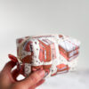 Pikowana kosmetyczka handmade w książkowy wzór z ilustracjami książek, zapinana na zamek, na jasnym tle w klimacie cozy.