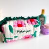 Zbliżenie na haft z imieniem na bawełnianej kosmetyczce handmade z falbanką.