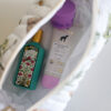 Bawełniana kosmetyczka handmade z botanicznym wzorem ziół, rumianku i mięty na jasnym tle.